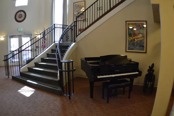 Interior view of a lobby with a piano and staircase