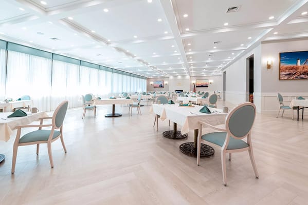 Bright and spacious dining room with tables set for meals