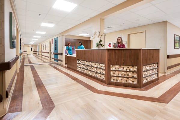 Staff interacting at a reception desk in the facility's hallway