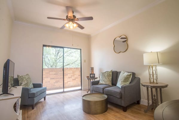 A comfortable living room featuring a gray sofa, armchair, and large windows with natural light.