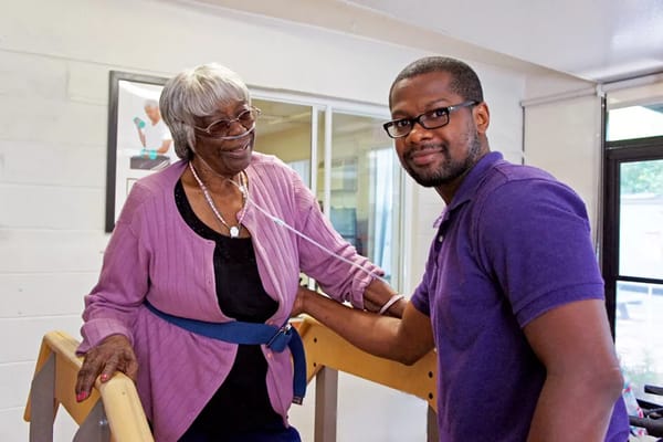 A staff member assisting a resident with therapy equipment