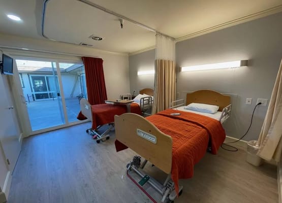 Shared resident room with two beds and exit to patio