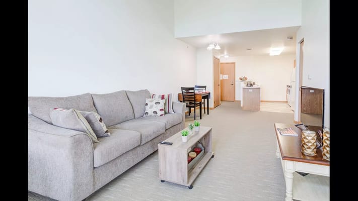 Bright interior of a resident room with a couch and dining area