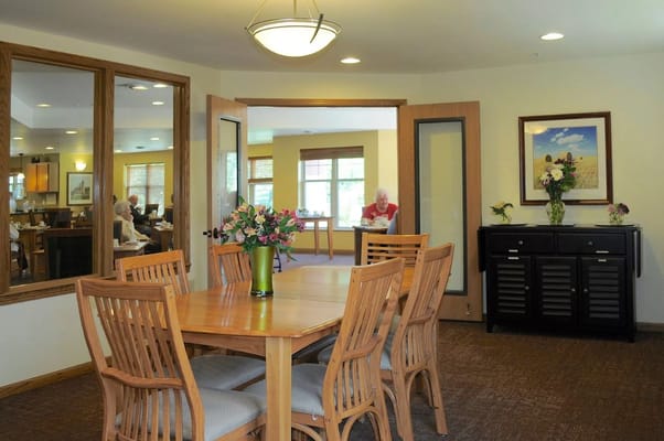 Common area with dining table and residents seated