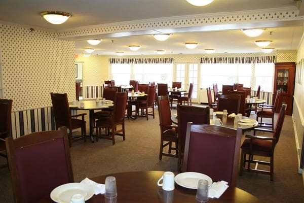 Interior dining room with tables and chairs set for a meal