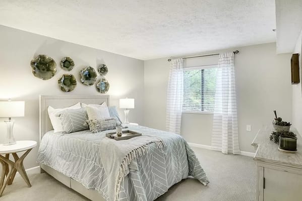 Well-decorated bedroom with light colors and window view