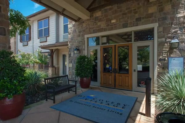 Entrance to Discovery Village with stone façade and landscaping