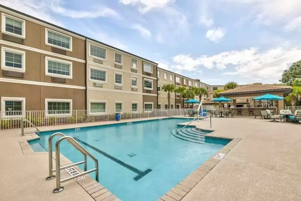 Outdoor pool area with seating and umbrellas