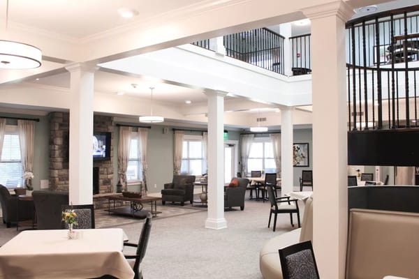 Spacious common area with seating and a fireplace at Dominion Senior Living