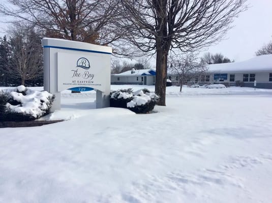 Signage in front of nursing home with snow covering the ground
