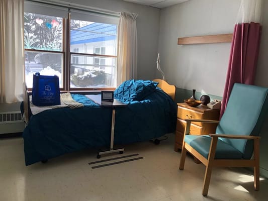 Cozy resident room with a hospital bed and chair