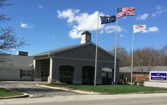 Front entrance of Edgewater Woods with flags and sign.