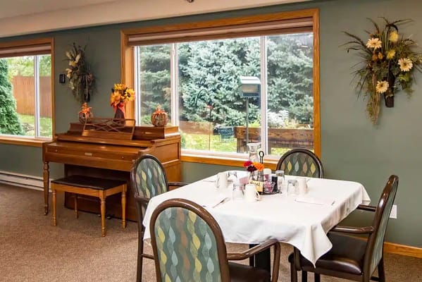 Dining area setup with a piano and natural light