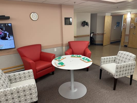 Cozy lounge area with red and patterned chairs and a small table