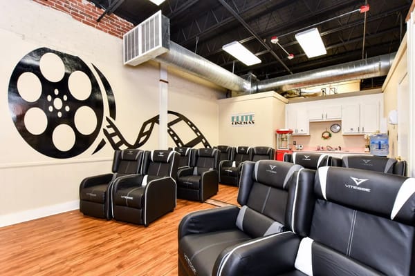 Interior of a common area with reclining chairs and a movie-themed mural