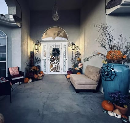 Entrance decorated for fall with pumpkins and spider webs