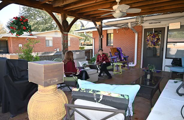 Two residents enjoying a conversation on the patio of England Oaks Active Adult Living