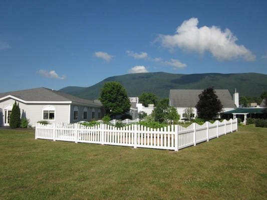 Exterior view of a senior living facility with a fenced garden
