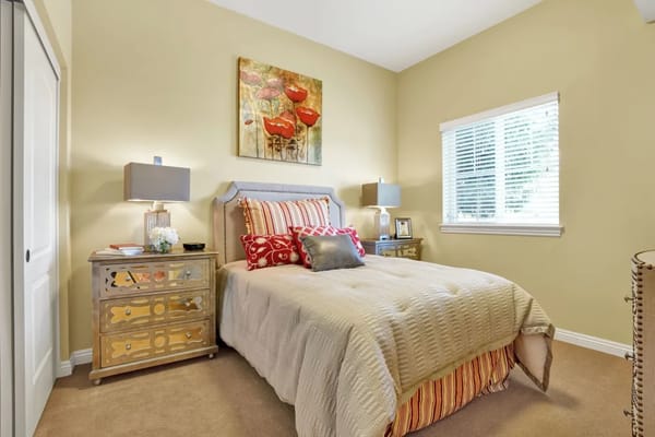 A well-decorated bedroom with a bed, nightstands, and artwork