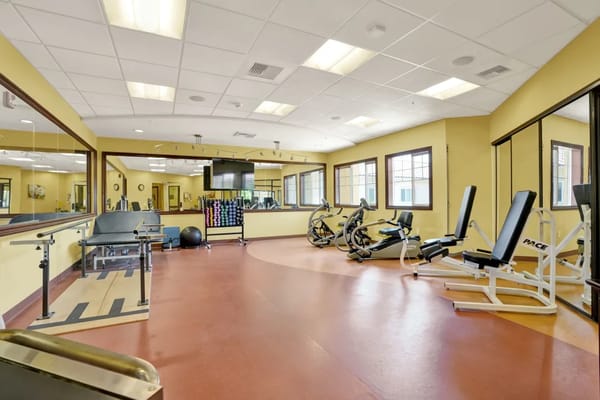 A spacious fitness room with exercise equipment at Estancia Del Sol facility.