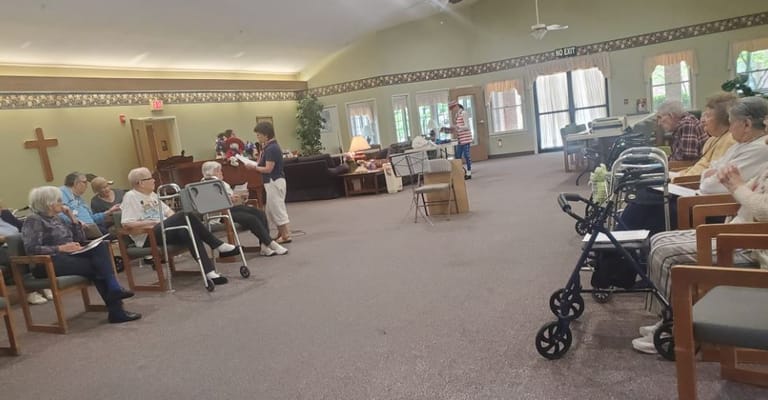 Seniors participating in a group activity in a spacious community room
