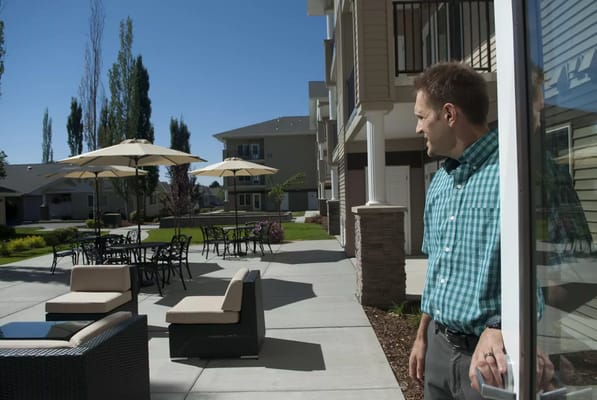 A man looking out to a patio area with seating