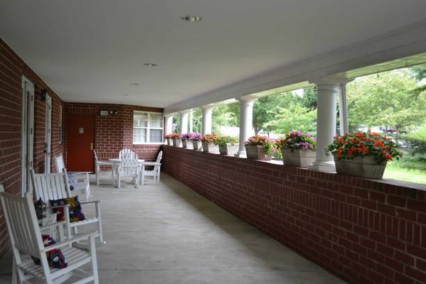 Covered porch area with flower pots and seating