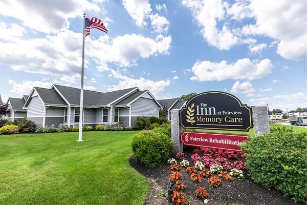 Exterior view of The Inn at Fairview Memory Care with American flag