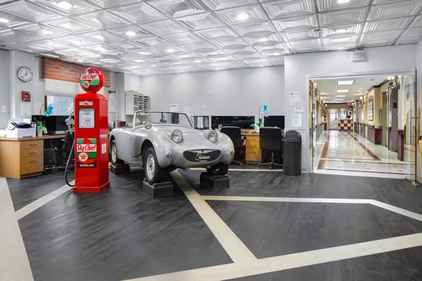 Vintage car displayed in the lobby next to an antique gas station pump