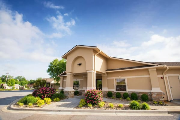 Exterior view of a senior living facility with landscaped garden