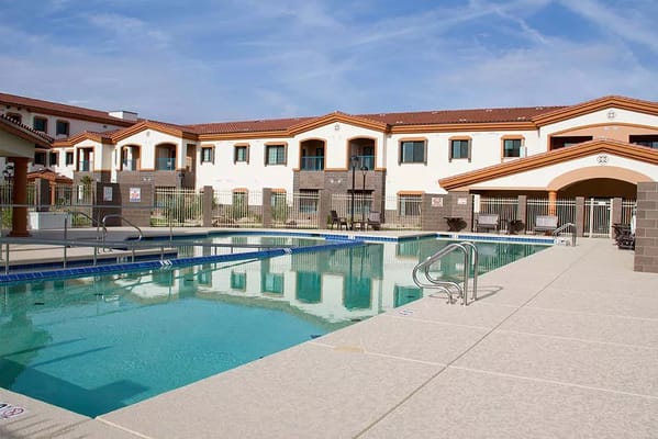 Outdoor pool area with residential building in the background