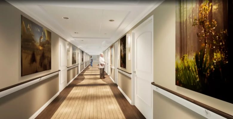 A corridor with art and a resident in a facility