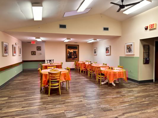 Dining area with orange tablecloths and artwork on the walls