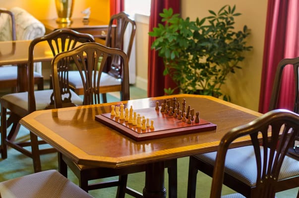 Chess pieces arranged on a table in a common room.