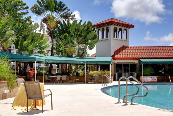 Outdoor pool area with seating and palm trees at Fountainview