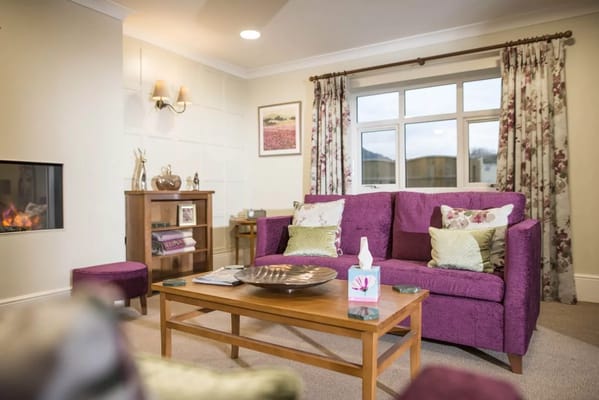 A cozy living room with purple furniture and decorations