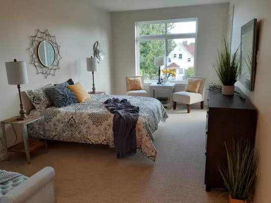 A cozy resident room with a bed and seating area