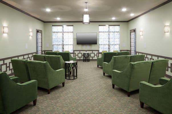 Interior common area with green chairs and a TV