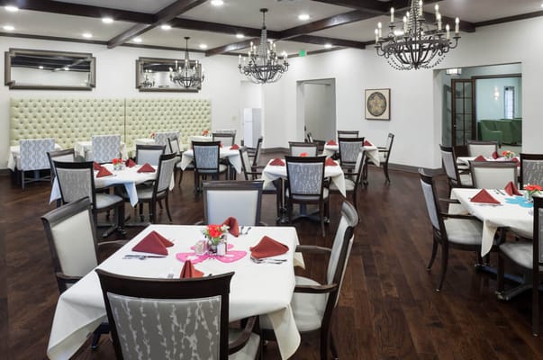 Bright dining room with tables set for residents