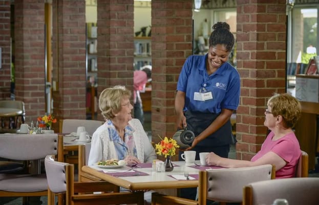 Staff serving meals to residents in the dining room