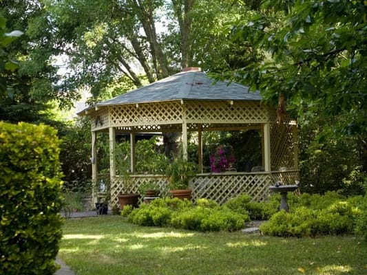 A gazebo surrounded by lush greenery in a garden