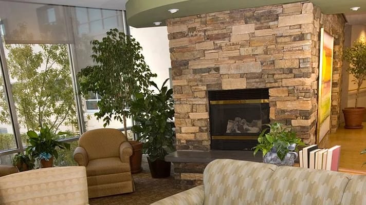 Cozy interior lounge area with plants and fireplace