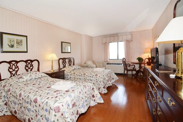 A well-furnished bedroom with two beds and a view.