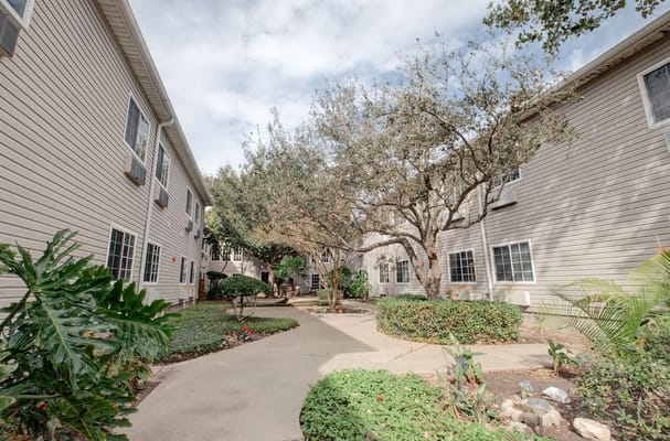 A peaceful courtyard surrounded by buildings and greenery.