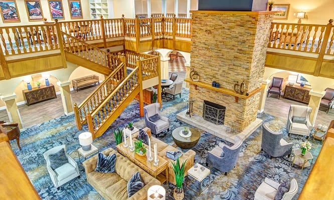 Spacious lobby with a stone fireplace and comfortable seating area.