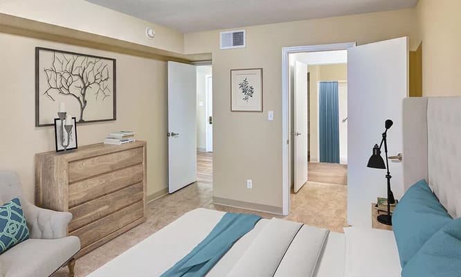 Cozy bedroom with dresser, artwork, and open doors
