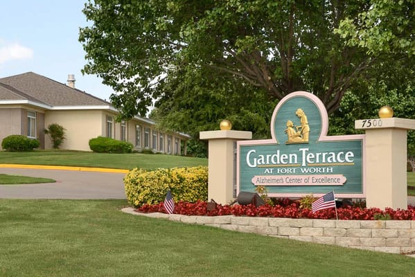 Sign at the entrance of Garden Terrace at Fort Worth with landscaped grounds.
