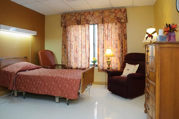 Cozy bedroom with a bed, armchair, and window curtains
