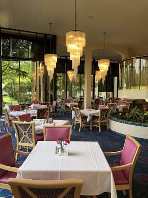Elegant dining room with chandeliers and pink chairs