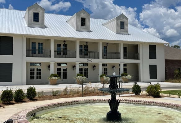 Exterior view of the Gardens of Somerset facility with a fountain